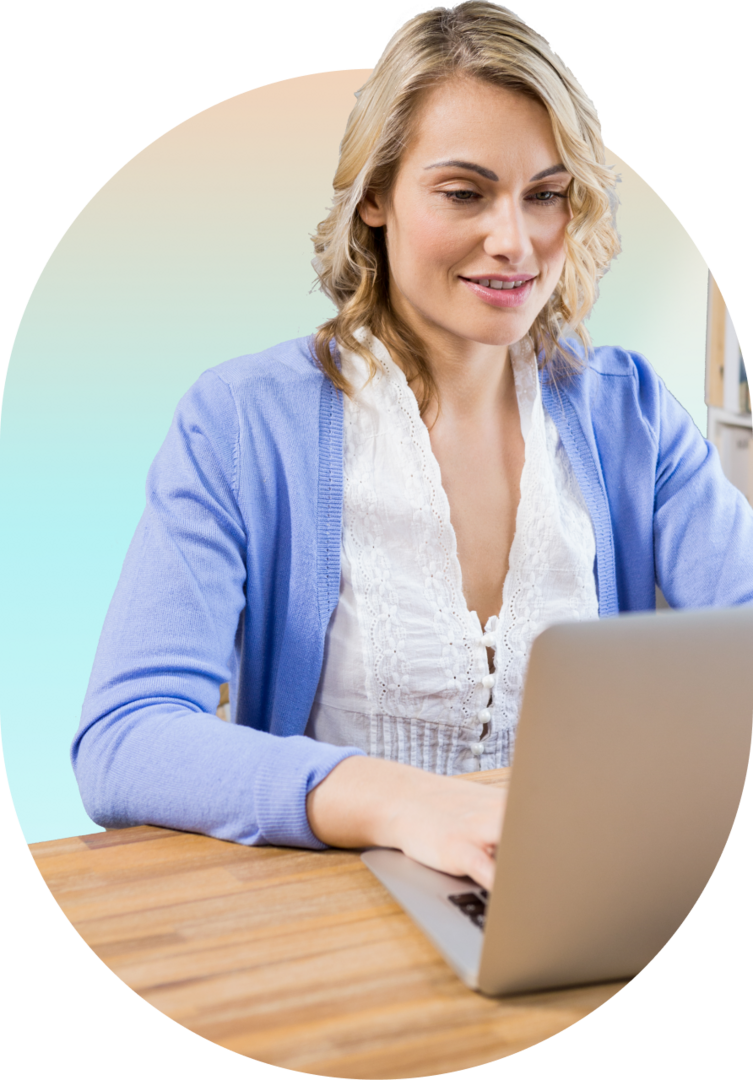 Female virtual assistant working on a laptop, wearing a blue cardigan and smiling.